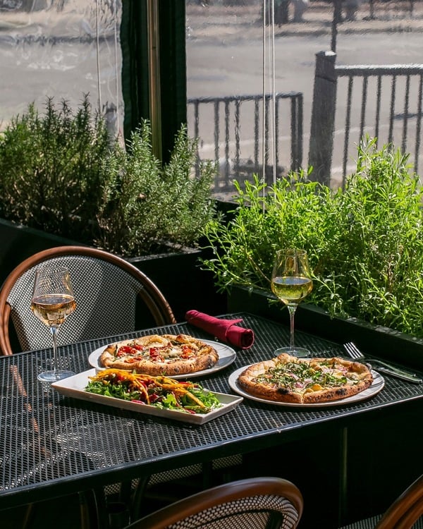 Artisan wood-fired pizza and garden dining showcasing hospitality careers Grosse Pointe Park culinary roles
